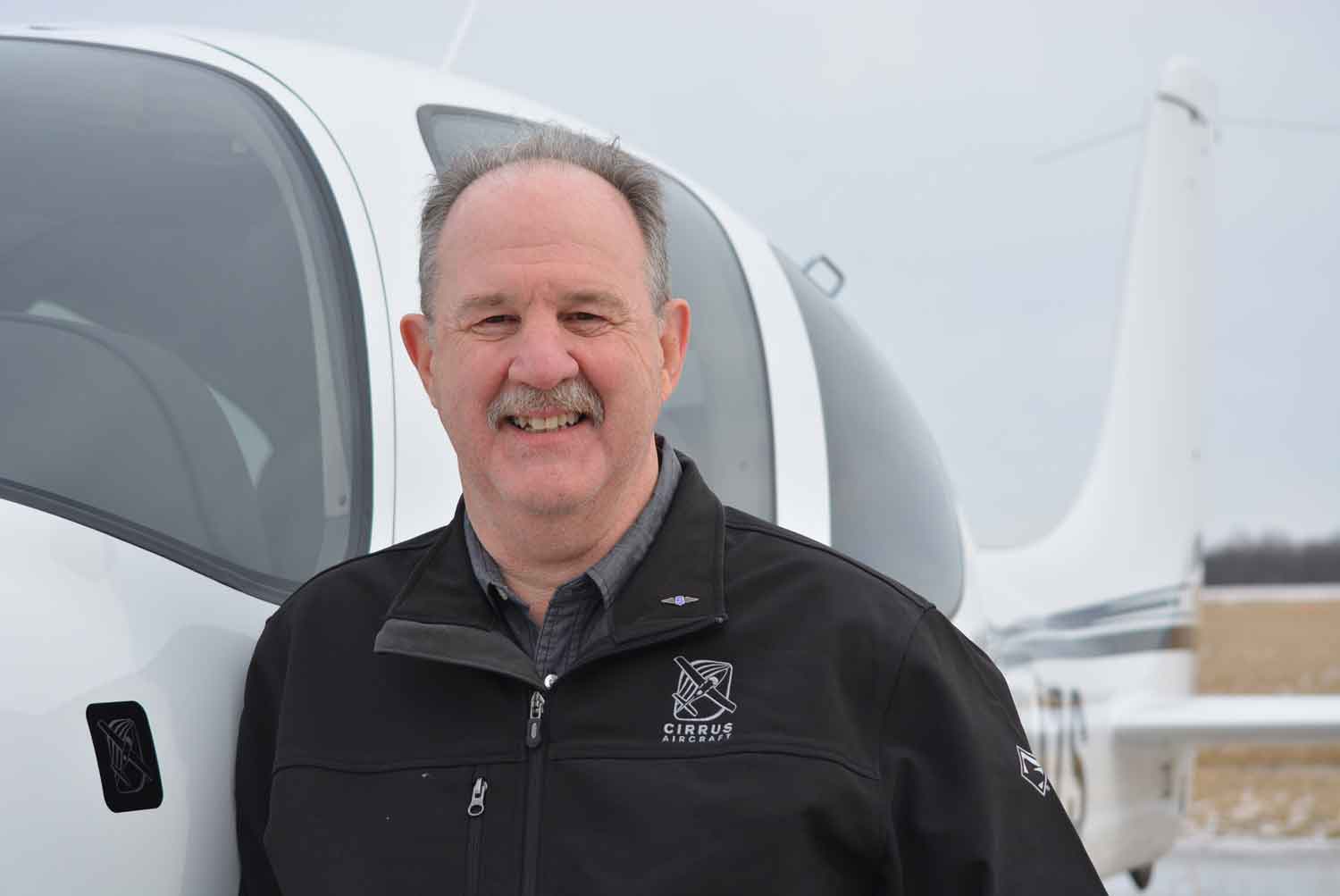 Ned Parks standing next to a Cirrus airplane.